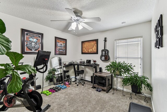 workout room featuring carpet, ceiling fan, baseboards, and a textured ceiling