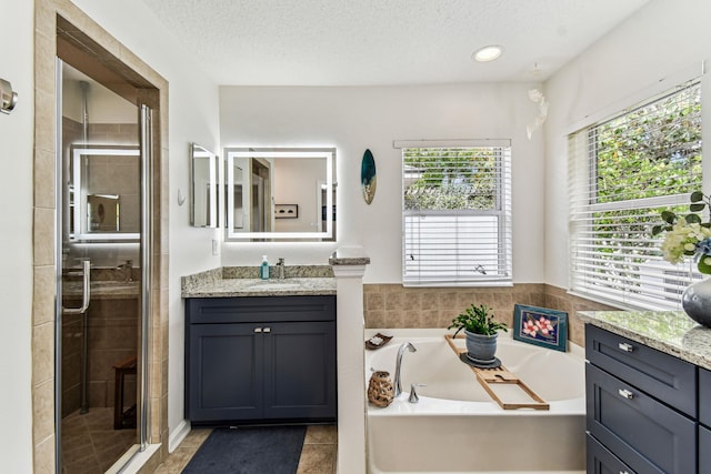 bathroom with a garden tub, a shower stall, vanity, tile patterned floors, and a textured ceiling