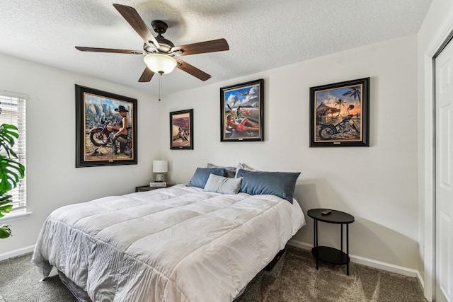bedroom featuring dark carpet, baseboards, a textured ceiling, and ceiling fan