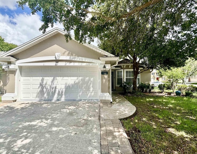single story home with stucco siding, a garage, and driveway