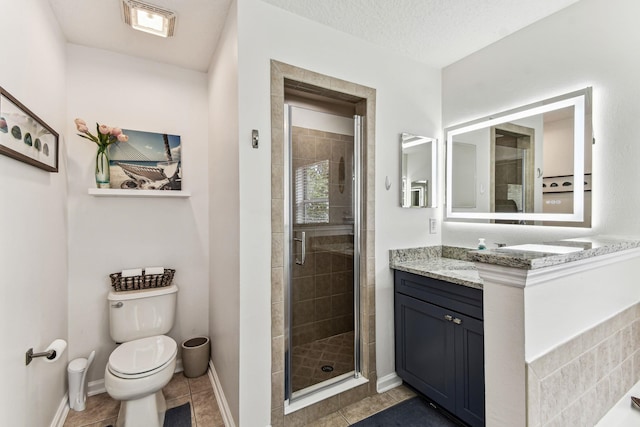 bathroom featuring a stall shower, vanity, tile patterned floors, toilet, and baseboards