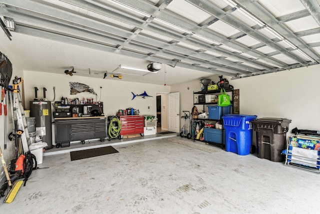 garage featuring electric water heater, a workshop area, and a garage door opener