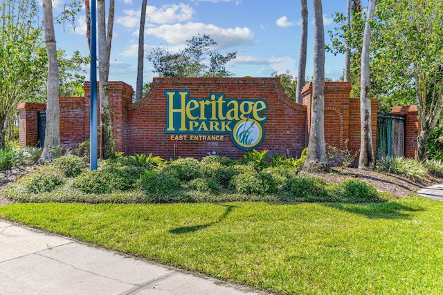 community / neighborhood sign featuring a yard