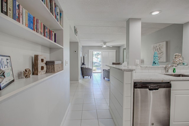 kitchen featuring ceiling fan, dishwasher, sink, light tile patterned floors, and white cabinets