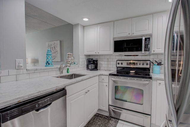 kitchen featuring light stone countertops, sink, white cabinetry, and stainless steel appliances