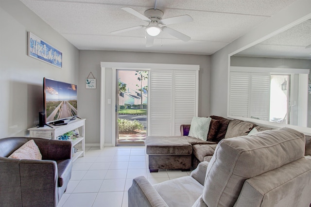 tiled living room featuring ceiling fan, a textured ceiling, and a wealth of natural light