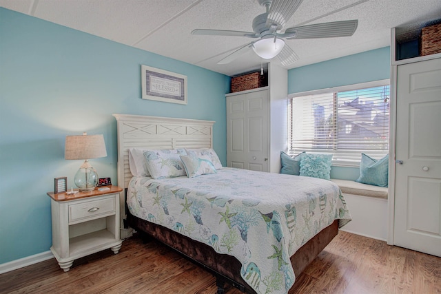 bedroom with hardwood / wood-style floors, a textured ceiling, a closet, and ceiling fan