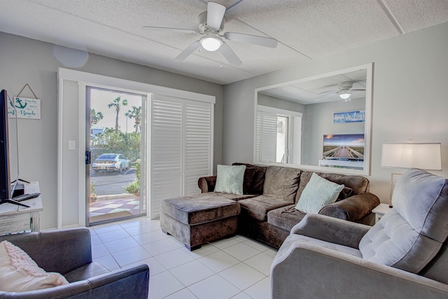 living room with ceiling fan, a textured ceiling, a wealth of natural light, and light tile patterned flooring