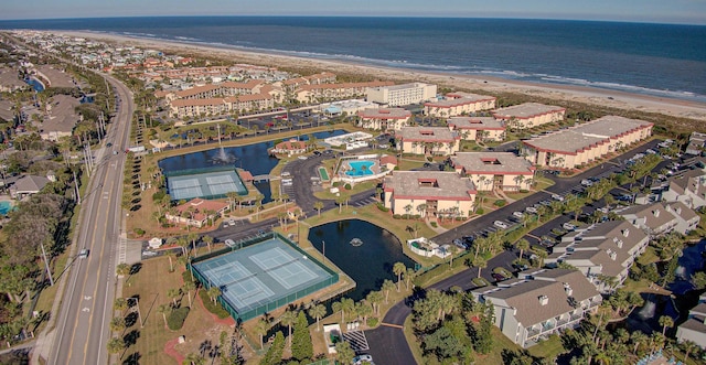 birds eye view of property featuring a water view and a beach view