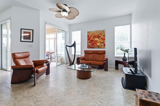 sitting room featuring a ceiling fan, plenty of natural light, and light tile patterned flooring