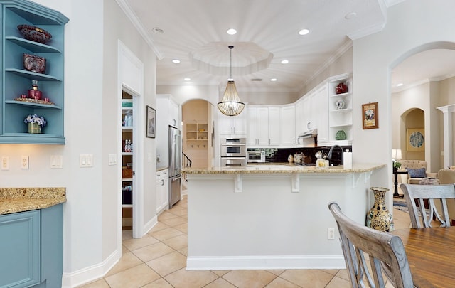 113 Holly Berry Ln, Saint Johns, FL 32259 - kitchen featuring open shelves, a peninsula, under cabinet range hood, stainless steel appliances, and arched walkways
