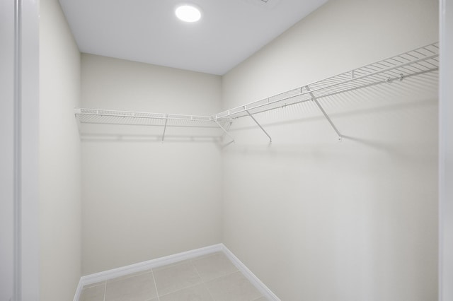 walk in closet with light tile patterned floors