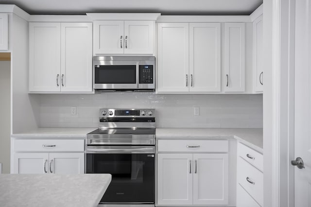 kitchen featuring white cabinetry, stainless steel appliances, and backsplash