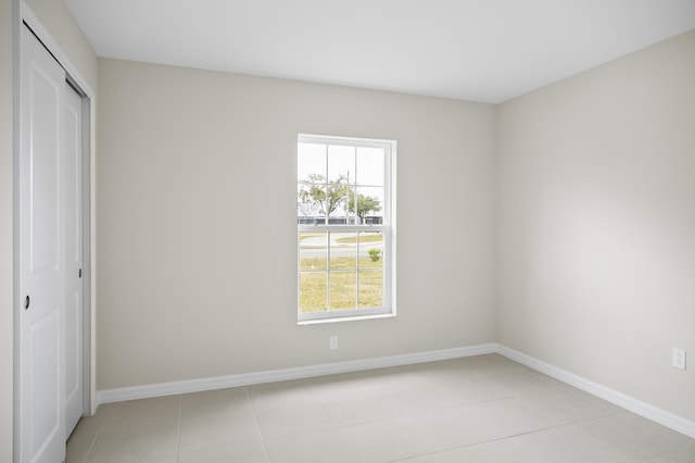 unfurnished bedroom with light tile patterned flooring and a closet