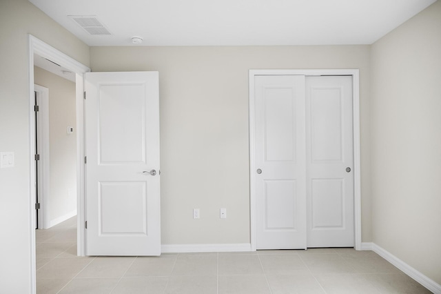 unfurnished bedroom with light tile patterned floors and a closet