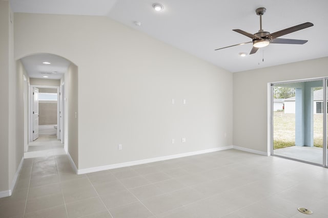 spare room with lofted ceiling, light tile patterned floors, and ceiling fan