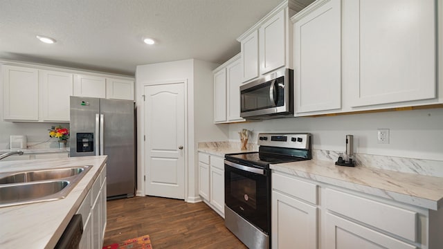 4004 Chihuahua Ct, Jacksonville, FL 32218 - kitchen with appliances with stainless steel finishes, dark wood-style flooring, white cabinetry, light countertops, and recessed lighting