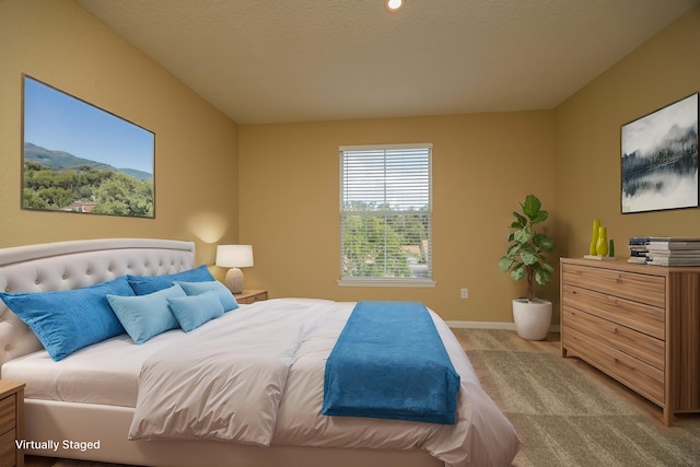 bedroom featuring a textured ceiling and light colored carpet