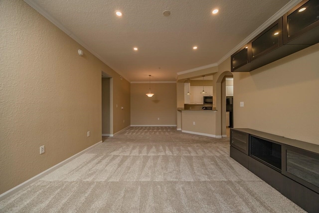 unfurnished living room with ornamental molding, light carpet, and a textured ceiling