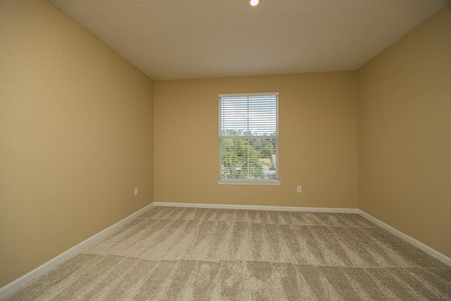 unfurnished room with light carpet and a textured ceiling