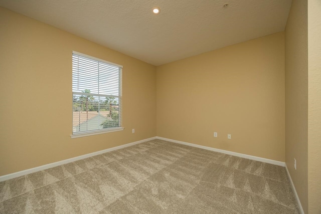 carpeted spare room with a textured ceiling