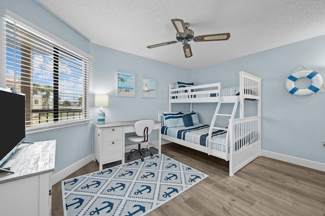 bedroom featuring ceiling fan, hardwood / wood-style flooring, and a textured ceiling