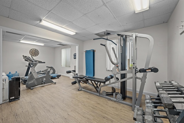 workout area featuring hardwood / wood-style flooring and a drop ceiling