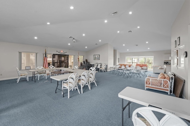 carpeted dining room featuring high vaulted ceiling