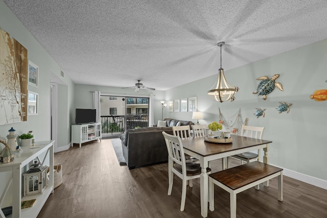 dining room with ceiling fan, dark hardwood / wood-style floors, and a textured ceiling