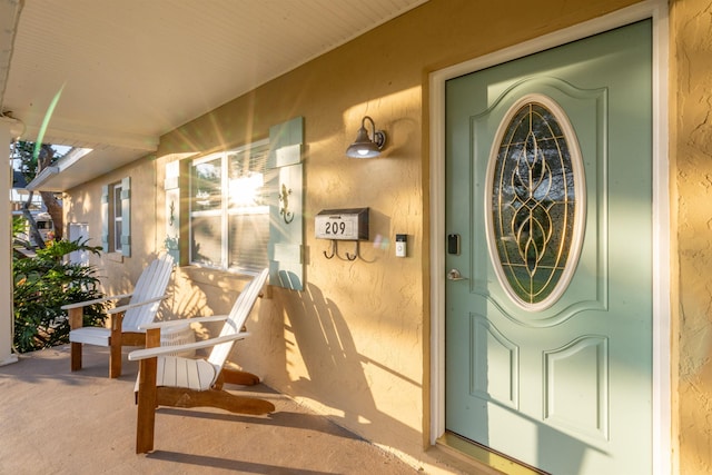 209 Alerto St, Saint Augustine, FL 32080 - doorway to property with covered porch and stucco siding