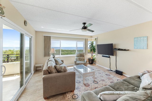 living room with ceiling fan and a textured ceiling