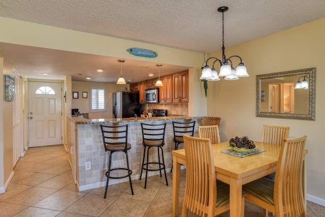 4 Ocean Trace Rd Unit 323, Saint Augustine Beach, FL 32080 - dining room featuring a chandelier, light tile patterned floors, and a textured ceiling