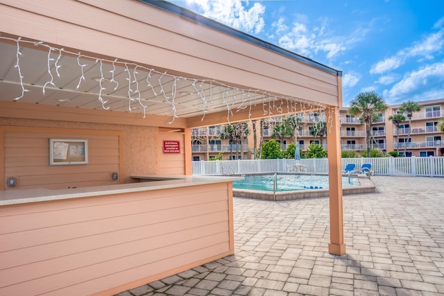 view of swimming pool featuring an outdoor bar and a patio