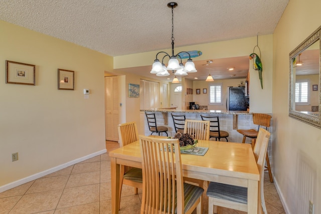 4 Ocean Trace Rd Unit 323, Saint Augustine Beach, FL 32080 - dining room with a chandelier, light tile patterned floors, and a textured ceiling