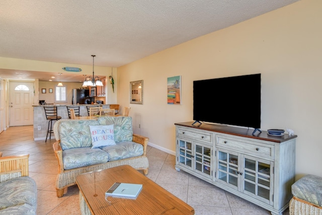 4 Ocean Trace Rd Unit 323, Saint Augustine Beach, FL 32080 - living room featuring a chandelier, light tile patterned flooring, and a textured ceiling