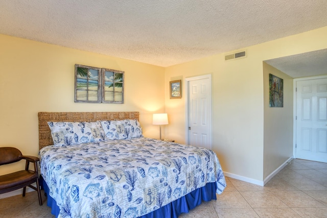 bedroom with light tile patterned flooring and a textured ceiling