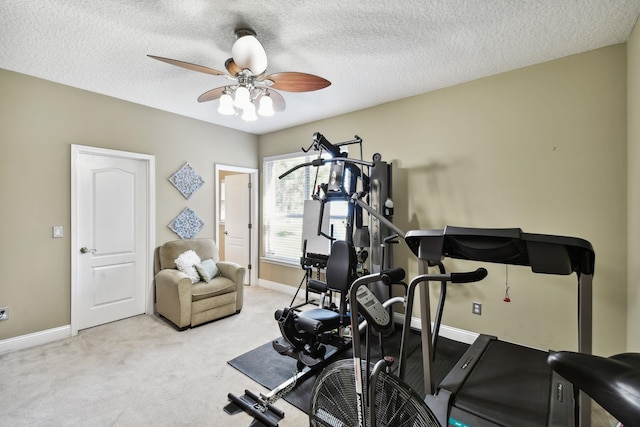 exercise room with ceiling fan, light colored carpet, and a textured ceiling