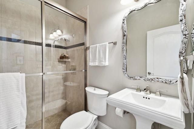 bathroom featuring toilet and an enclosed shower