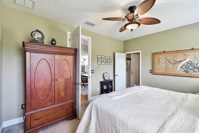 carpeted bedroom with ceiling fan and a textured ceiling