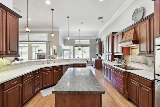 kitchen with pendant lighting, a center island, light hardwood / wood-style floors, and a textured ceiling