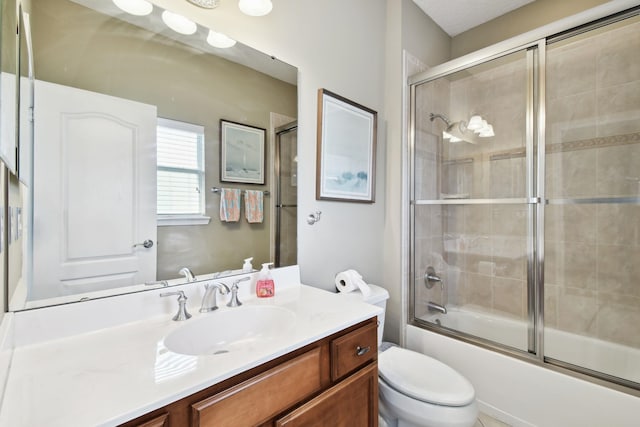 full bathroom featuring vanity, toilet, and bath / shower combo with glass door