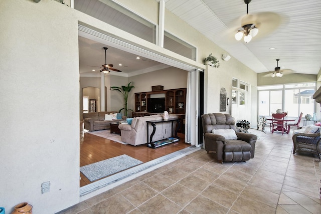 living room with ceiling fan, light wood-type flooring, and crown molding