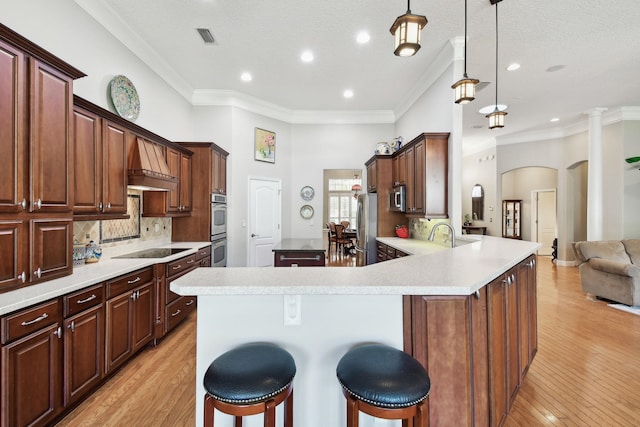 kitchen with pendant lighting, kitchen peninsula, a breakfast bar area, and light hardwood / wood-style flooring