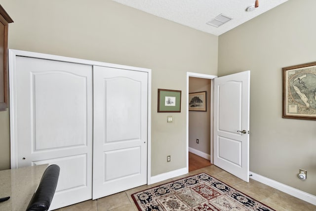 tiled office space with a textured ceiling