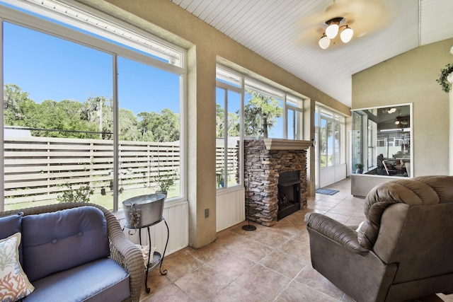 sunroom / solarium with ceiling fan, a fireplace, wooden ceiling, and lofted ceiling