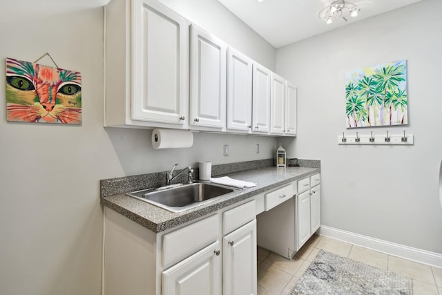 kitchen with white cabinets, light tile patterned floors, and sink