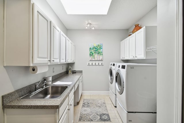 washroom with cabinets, sink, a skylight, separate washer and dryer, and light tile patterned floors