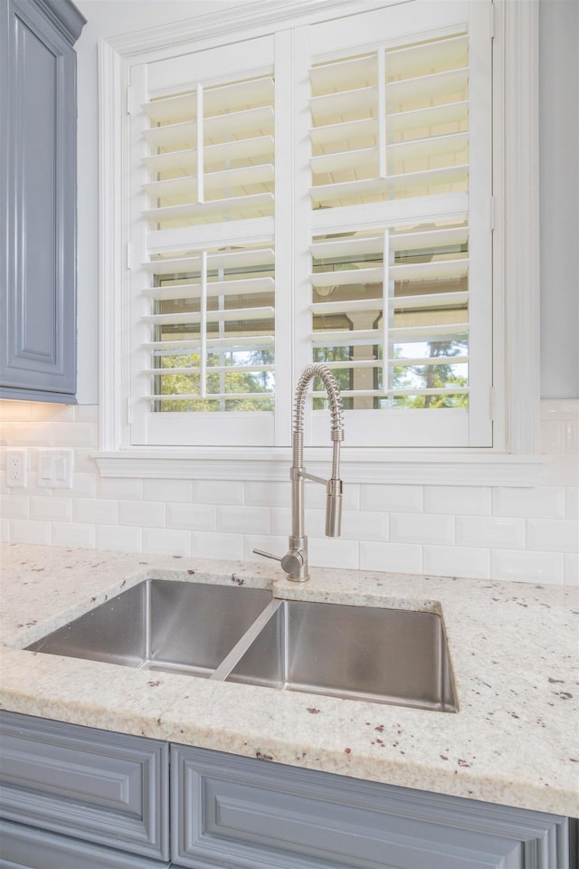 301 Graciela Cir, Saint Augustine, FL 32086 - room details featuring decorative backsplash, a sink, light stone counters, and gray cabinets