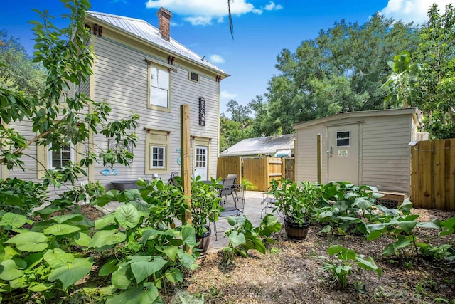 back of house with a patio and a shed