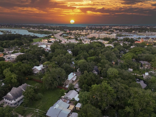 aerial view at dusk featuring a water view